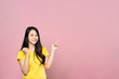 © Kawee - Portrait of Asian beautiful young woman pointing one hand with finger on upper left side with smile face. The girl standing and looking at camera in studio. Advertisement & presentation concept.
