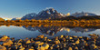 Panoramic reflection of the peaks of the Cuernos and Torres del Paine in Lago Grey with an iceberg at Sunrise, Torres del Paine national park, Patagonia, Chile.