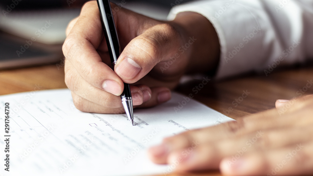 Businessman signing a document in office - obrazy, fototapety, plakaty 