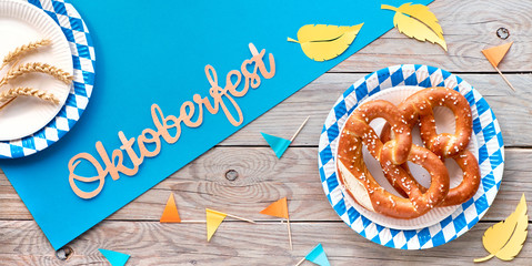 Wall Mural - Oktoberfest square background, pretzels on blue and white checkered disposable paper plates