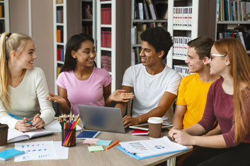 Friends discussing homework, studying at library together