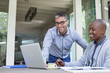 © Greatstock - Young men working on the laptop and smiling