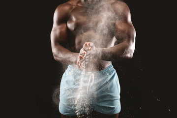 Cropped image of african guy putting powder on his hands