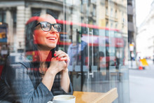 Smiling Woman Behind Windowpane In A Cafe