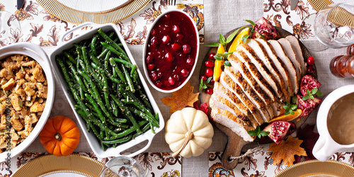 Fotomural Thanksgiving dinner table with sliced turkey and sides, overhead shot