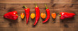 Assortment of fresh peppers on a textured dark wood background