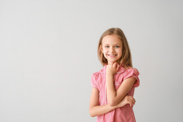 Portrait of happy little girl on light background