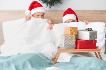 Wall Mural - Tray with Christmas gift boxes on bed of mature couple