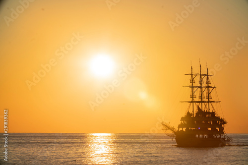 old pirate ship sailing at sea sunset