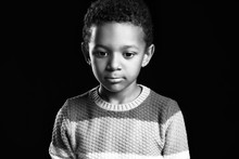 Black And White Portrait Of Sad African-American Boy On Dark Background