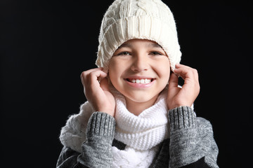 Wall Mural - Happy little boy in warm clothes on dark background