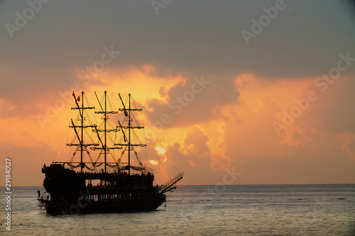 old pirate ship sailing at sea sunset