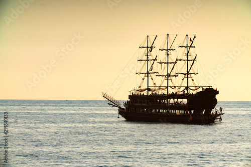 old pirate ship sailing at sea sunset
