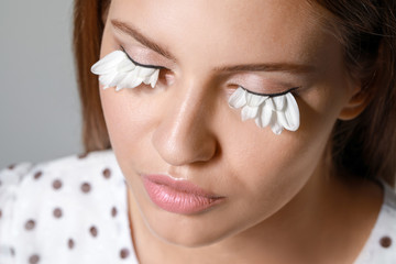 Poster - Young woman with creative eyelashes on grey background, closeup