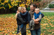 © Rob and Julia Campbell/Stocksy - Happy, active family outside standing in the fall leaves togethe