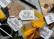 © Laura Stolfi/Stocksy - Wrapping christmas presents witt hand written tags and drafting a list of all the people whi are going to receive the gifts