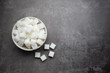 White sugar cubes in bowl on table.