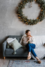 Woman Having Cookie On Sofa In Xmas Time