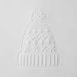 © Yaroslav Danylchenko/Stocksy - Embossed pattern on a gray cardboard in the form of a hat decorated with snowflakes and Christmas trees with copy space. Layout for Christmas card. Top view
