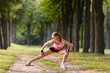 © Olga Mishyna - sport girl making exercises outdoors. Young sport woman in a park. Sport and fitness on open air. Exercise lunge leg on the grass and stretching