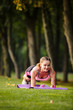 © Olga Mishyna - sport girl making exercises outdoors. Young sport woman in a park. Sport and fitness on open air. Exercise lunge leg on the grass and stretching