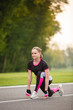 © Olga Mishyna - sport girl making exercises outdoors. Young sport woman in a park