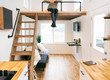 © Sean Locke Photography/Stocksy - Home: Woman With Legs Dangling From Loft