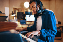 Young Musician Playing Keyboards In A Recording Studio