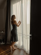 © Milles Studio/Stocksy - Content woman in nightwear near window
