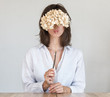 © papa - A young woman covers her face with dry hydrangea flowers and making lips into a kiss.