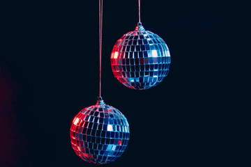 Wall Mural - Sparkling disco balls hanging in the air against black background