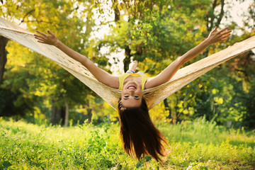 Wall Mural - Young woman resting in comfortable hammock at green garden