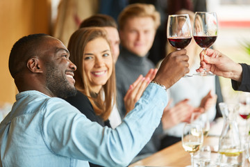 Wall Mural - Afrikanischer Mann beim Anstoßen mit Rotwein