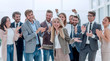 © ASDF - happy young woman standing in front of her jubilant colleagues
