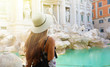 Travel in Europe. Back view of attractive woman looks Trevi fountain famous landmark in Rome. Girl enjoy holiday in Italy.