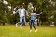 © deagreez - Full body photo of cute pair holding hands jumping high in green park wear denim outfit