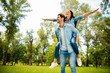 © deagreez - Dreamy pair flying away together at summer green street spread arms sides wear denim outfit