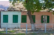 Old Adobe House Painted In Two Colors With Green Shutters On The Windows On A Summer Day. Krasnodar Territory, Russia