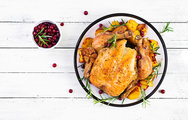 Roasted turkey garnished with cranberries on a rustic style table decorated  autumn leaf. Thanksgiving Day. Baked chicken. Top view