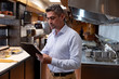 © Wavebreak Media - Restaurant manager holding a clipboard in a kitchen