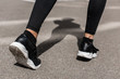 © LIGHTFIELD STUDIOS - cropped view of sportswoman in black sneakers on street