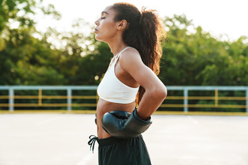 Canvas Print - Photo of calm woman in boxing gloves standing while doing workout