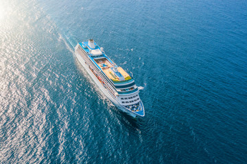 Wall Mural - Cruise ship liner sails in the sea leaving a plume on the surface of the water seascape. Aerial view The concept of sea travel, cruises.