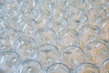 empty clean glasses standing in a row on a table prepared by the bartender for champagne and wine. s