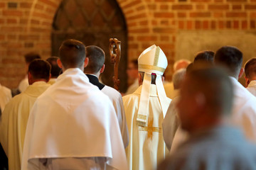 bishop goes to mass accompanied by priests