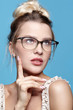 © Serg Zastavkin - Portrait of attractive young woman in glasses on blue background