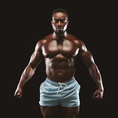 Wall Mural - Young athletic black man showing naked muscular body