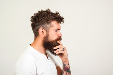 Profile of smart and creative handsome man over white background. Bearded man is thinking, trying solve problem. Hipster making hard decision