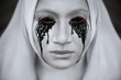 © ksi - A gloomy portrait of a ghostly pale nun in white robes with black eye sockets and black smudges under them.Halloween, horror.