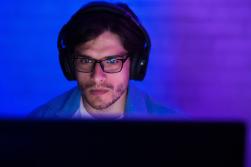 Wall Mural - Young man in headset playing game at home